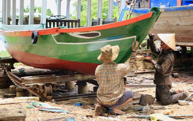 Atelier de réparation de vieux bateaux avec leurs yeux caractéristiques sur l'île de Cam Kim et le village de Kim Bong à côté d’Hoi Han