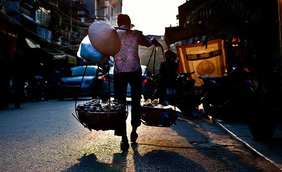 Vendeuse à la palanche dans le vieux quartier de Phan Huy Ich 